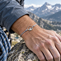 The Power of Color – The Mountains Are Calling – mountain-themed bracelet on a light gray cord